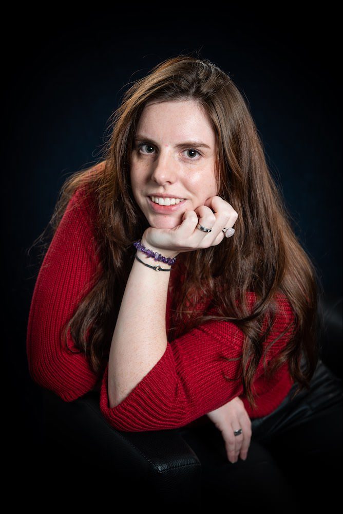 Studioportrait einer jungen Frau im roten Pullover
