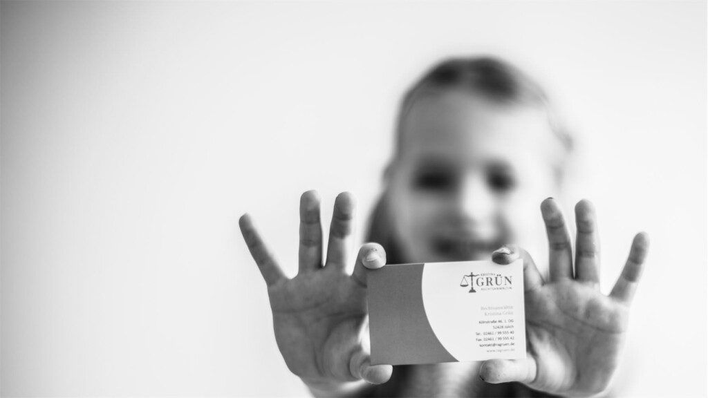 Kind streckt Visitenkarte in Richtung Kamera