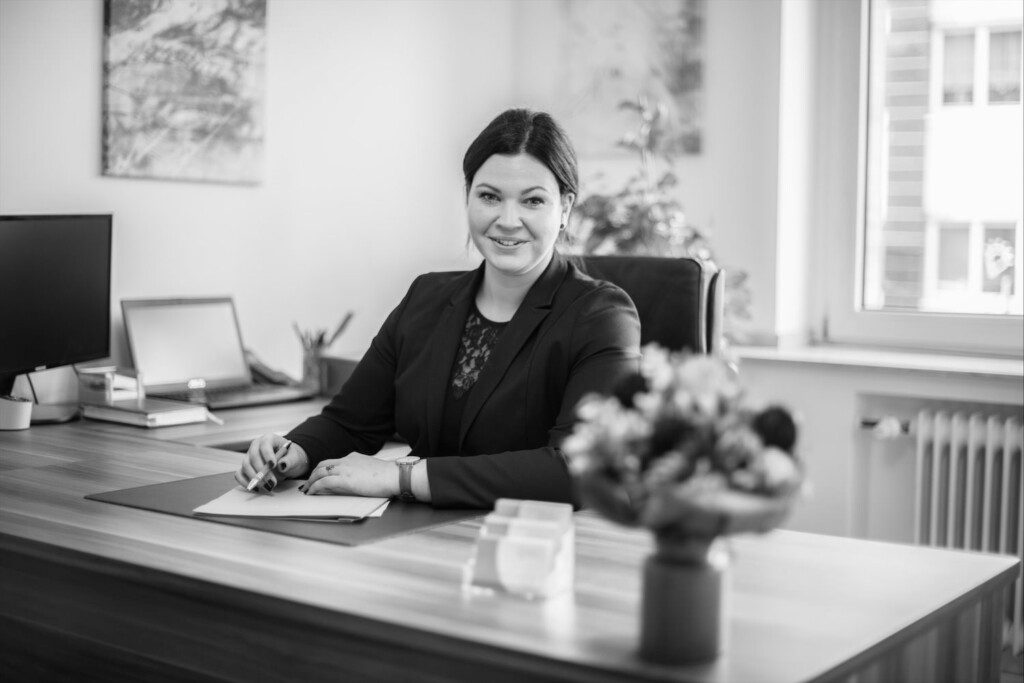 SW Portrait Rechtsanwältin Kristina Grün an einem Schreibtisch