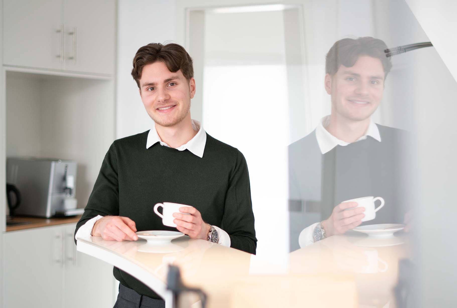 Ein junger Mann mit einer Kaffeetasse in der Hand